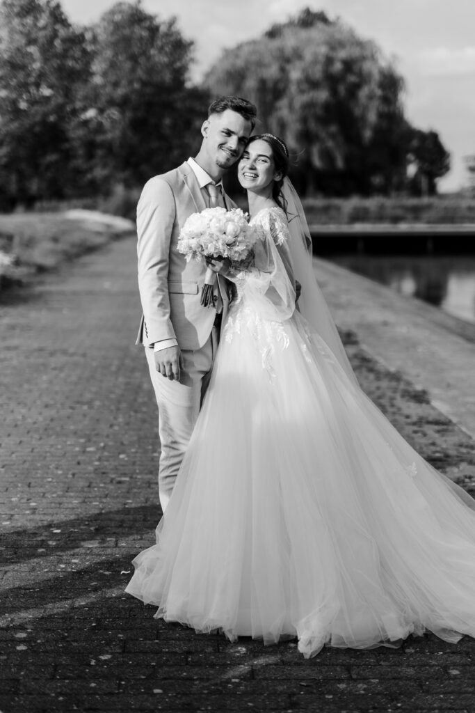 Hochzeitsfotograf-Guetersloh-Brautpaar-umarmt-sich-laechelnd-schwarzweiss