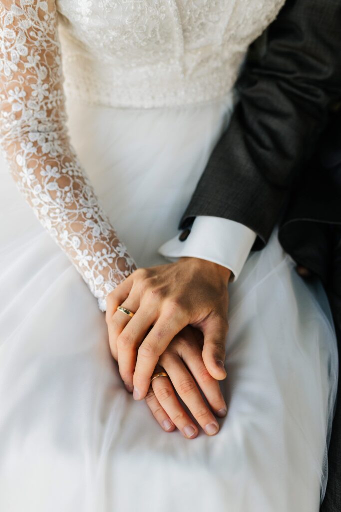 Hochzeitsfotograf-Guetersloh-Haende-des-Brautpaars-auf-dem-Brautkleid